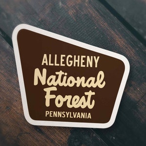 May include: A brown and white sticker with the text "Allegheny National Forest Pennsylvania".