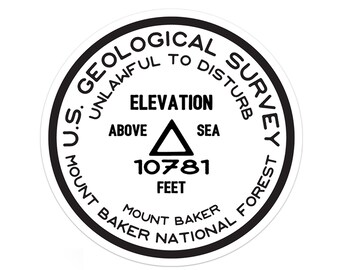 May include: A black and white circular sticker with the text "U.S. GEOLOGICAL SURVEY UNLAWFUL TO DISTURB" around the edge. The center of the sticker has the text "ELEVATION ABOVE SEA 10781 FEET MOUNT BAKER NATIONAL FOREST MOUNT BAKER".