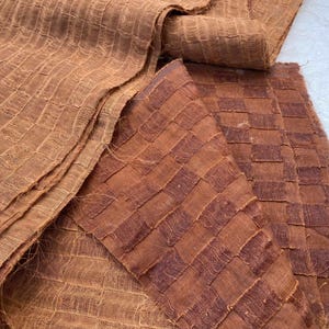 May include: Two pieces of brown fabric with a woven checkered pattern. The fabric has a rough, textured surface.