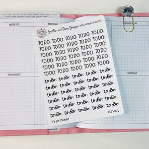 May include: A sheet of white paper with black handwritten "to do" stickers. The stickers are arranged in rows and columns. The paper is labeled "To Do Header" and "TDH-001".