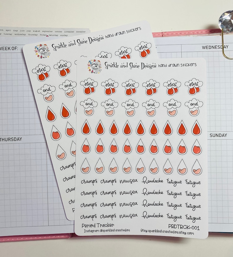 Pu&ograve; includere: Un foglio di adesivi per un tracker del ciclo mestruale. Gli adesivi sono rossi e rosa e presentano una variet&agrave; di disegni, tra cui gocce di pioggia, nuvole e testo. Il testo include "start", "end", "cramps", "nausea", "headache", "fatigue", e "Period Tracker".