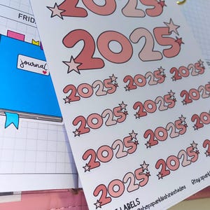 May include: A sheet of stickers with the year 2025 printed in pink and white with a star next to each number. The stickers are on a white background and the text "2025 LABELS" is printed at the bottom of the sheet.