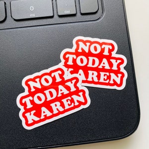 May include: Two red and white stickers with the text "Not Today Karen" on a black laptop.