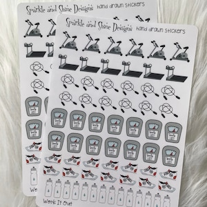 May include: A sheet of stickers featuring various fitness-themed illustrations, including exercise equipment, weights, water bottles, and sneakers. The stickers are printed on white paper with black outlines and gray fill. The text "Sparkle and Shine Designs hand drawn stickers" and "Work It Out" are printed on the sheet.