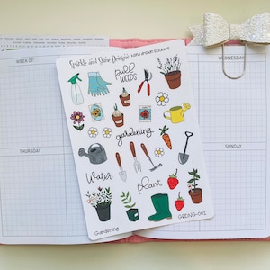 May include: A sheet of gardening themed stickers with illustrations of gardening tools, plants, flowers, and a watering can. The stickers are white with black outlines and colorful accents. The text on the sheet reads "Sparkle and Shine Designs hand drawn stickers", "Pull Weeds", "Gardening", "Water", "Plant", and "GRDNG-001".