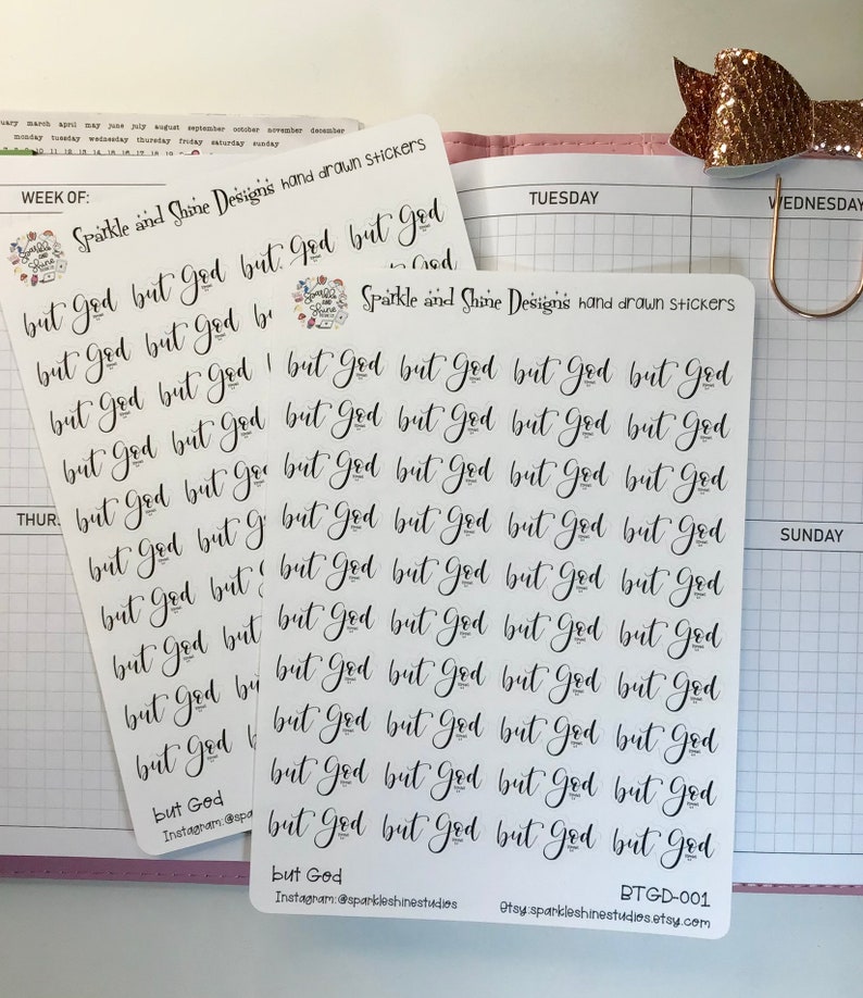 May include: A sheet of white sticker paper with the phrase "But God" repeated multiple times in black cursive handwriting. The stickers are designed for use in a planner or journal.