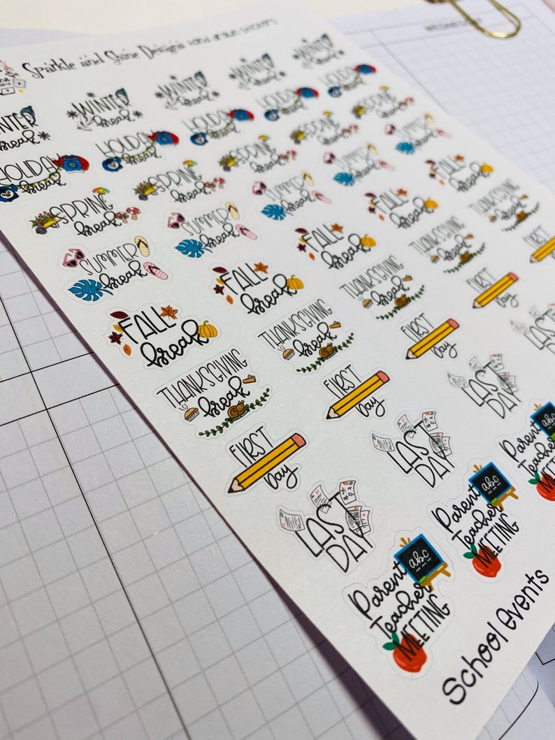 May include: A sheet of colorful stickers with various school-related themes, including "Fall Break", "Thanksgiving Break", "First Day", "Last Day", and "Parent Teacher Meeting".