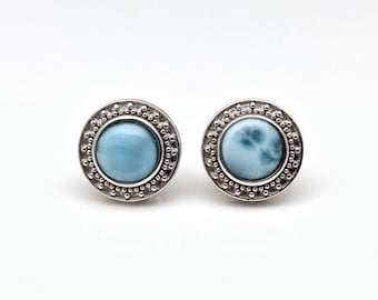 May include: A pair of silver earrings with a blue and white stone set in a beaded bezel.