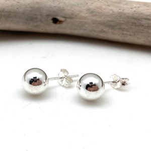 May include: A pair of silver ball stud earrings. The earrings are simple and elegant, and they would make a great gift for any occasion.