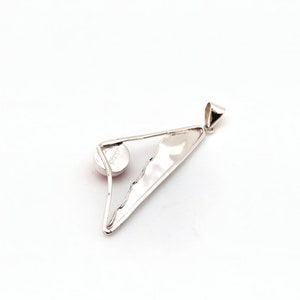 May include: Silver pendant with a triangular shape and a round, light pink stone set in the center. The pendant has a textured surface and a loop at the top for attaching a chain.