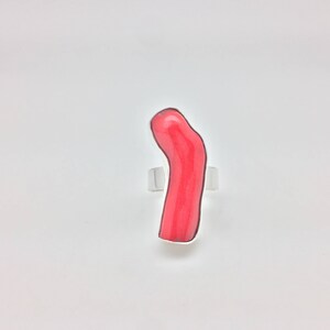May include: A ring with a bright pink coral stone set in silver.