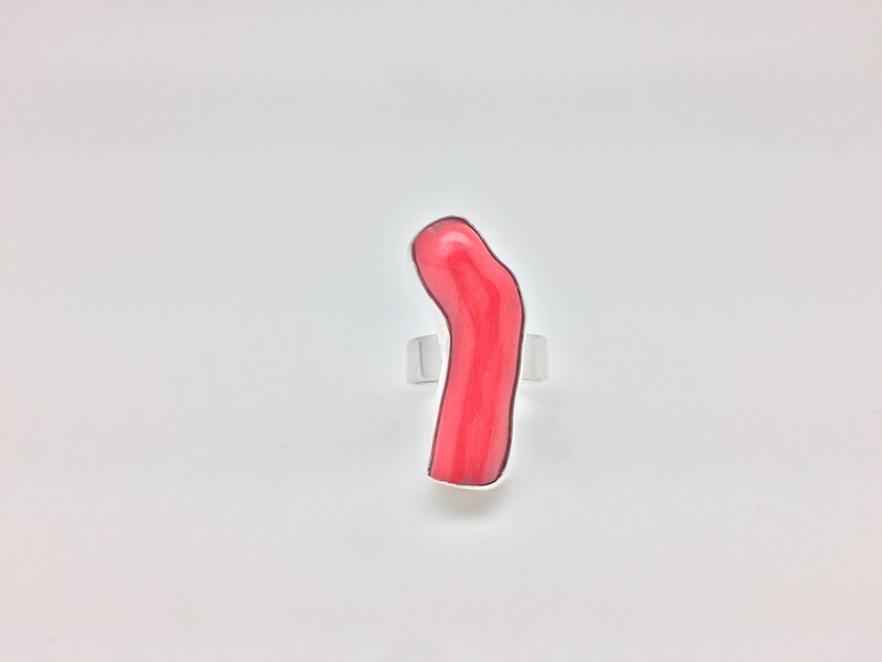 May include: A ring with a bright pink coral stone set in silver.