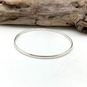 May include: A simple silver bangle bracelet.