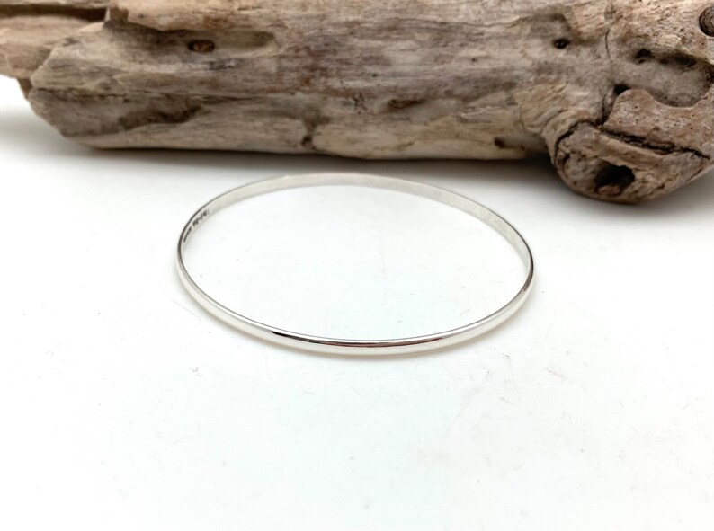 May include: A simple silver bangle bracelet.