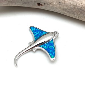 May include: A silver pendant shaped like a manta ray with blue opal inlay.