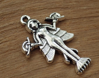 May include: Silver charm pendant featuring a winged female figure with outstretched arms holding a staff in each hand. The figure has a detailed design and a textured surface.