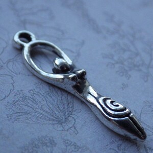 Puede incluir: Encanto de plata con un colgante que representa una figura femenina estilizada con un dise&ntilde;o en espiral. El encanto es un s&iacute;mbolo de lo divino femenino y se utiliza a menudo en la fabricaci&oacute;n de joyas.