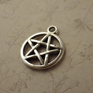 Puede incluir: Un dije de plata con forma de estrella de cinco puntas con un dise&ntilde;o detallado. La estrella es un s&iacute;mbolo popular en diversas culturas y pr&aacute;cticas espirituales.