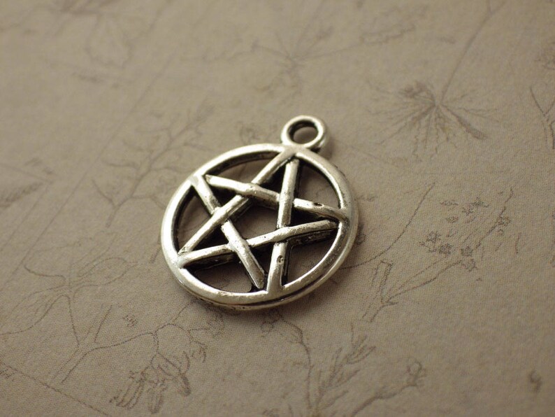 Puede incluir: Un dije de plata con forma de estrella de cinco puntas con un dise&ntilde;o detallado. La estrella es un s&iacute;mbolo popular en diversas culturas y pr&aacute;cticas espirituales.