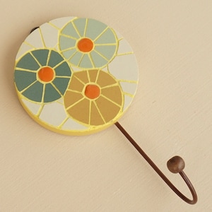 Round wall hanging hook with organic circular mosaic art patterns.