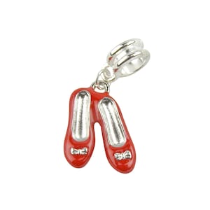 May include: Silver charm with a pair of red shoes with silver bows. The charm has a silver loop for attaching to a bracelet.