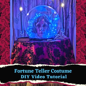 May include: A fortune teller costume setup featuring a crystal ball with a woman's head inside, illuminated with blue lights. The table is draped with a purple cloth with a black floral pattern. The text reads "Fortune Teller Costume DIY Video Tutorial."