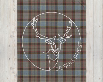 May include: A brown, blue, and yellow plaid throw blanket with a white circle in the center. The circle contains a line drawing of a deer head with antlers and the text "Je suis prest" in French.