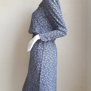 May include: A blue and white floral print dress with long sleeves and a gathered waist.