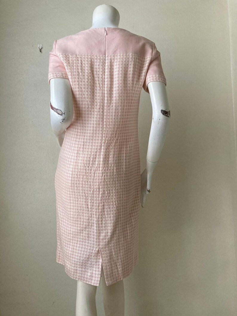 May include: A pink and white gingham dress with short sleeves. The dress has a fitted bodice and a slightly flared skirt.