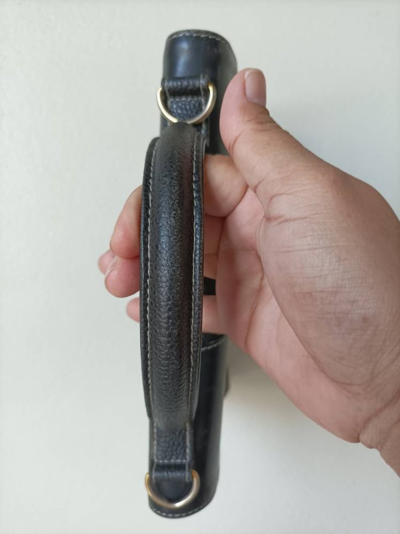 May include: A black leather handbag with a top handle and gold hardware.