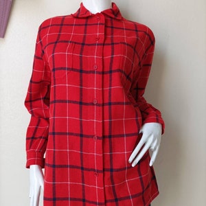 May include: A red and blue plaid long-sleeved shirt with a button-up front and two chest pockets.