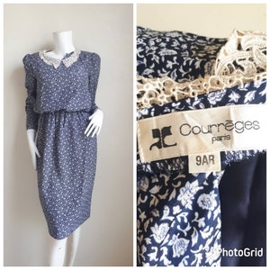 May include: A blue and white floral print dress with a white lace collar and long sleeves. The dress has a fitted bodice and a slightly flared skirt. The dress has a label that reads "Courr&egrave;ges Paris 9AR".