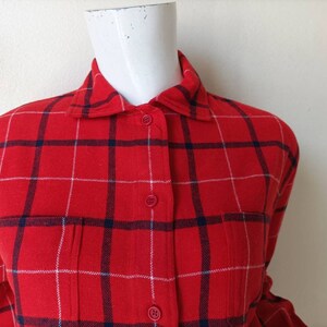 May include: Red and white plaid flannel shirt with a button-up front and long sleeves.