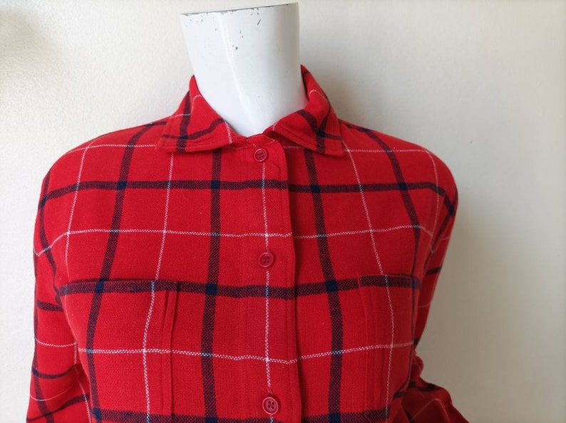 May include: Red and white plaid flannel shirt with a button-up front and long sleeves.