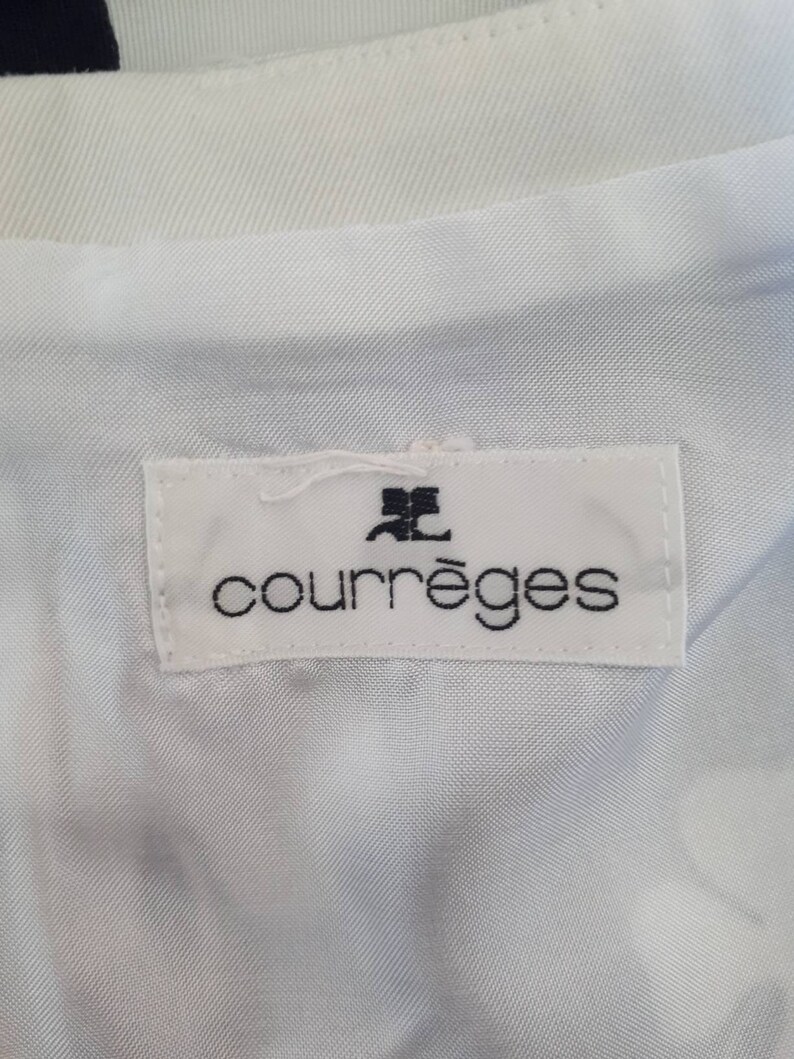 Pu&ograve; includere: Etichetta bianca con testo nero che recita "Courr&egrave;ges" con un piccolo logo nero sopra il testo.