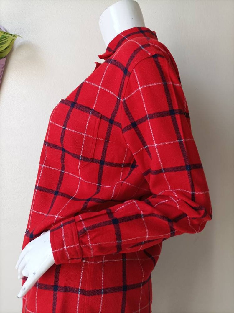 May include: Red and blue plaid long-sleeve shirt with a white pocket.