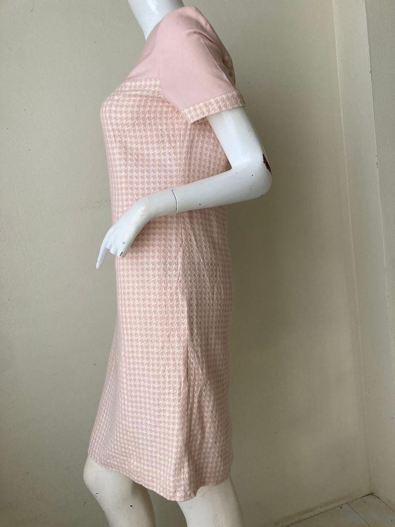 May include: A pink and white gingham dress with short sleeves. The dress has a fitted bodice and a slightly flared skirt.