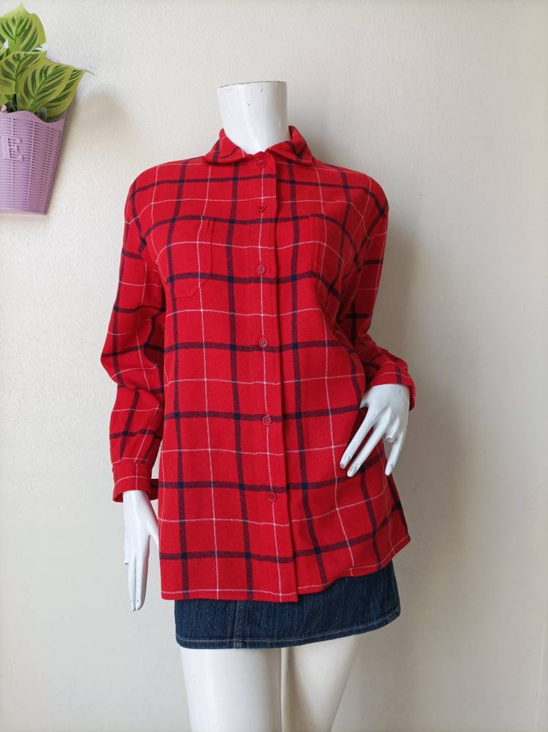 May include: A red and white plaid long-sleeved shirt with a blue and white checkered pattern. The shirt has a button-down collar and a chest pocket.