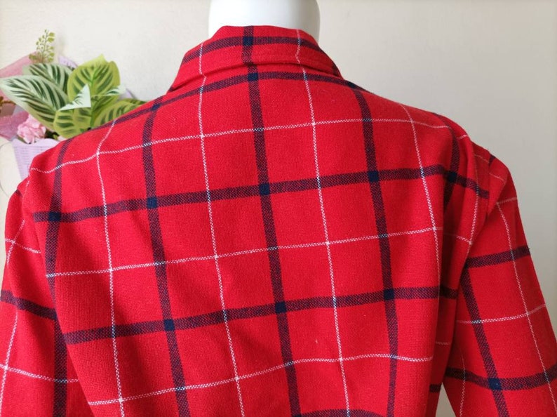 May include: Red and white plaid flannel shirt with a blue and white plaid pattern.
