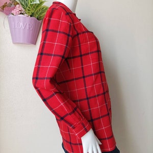 May include: Red and blue plaid long-sleeved shirt with a button-up front.