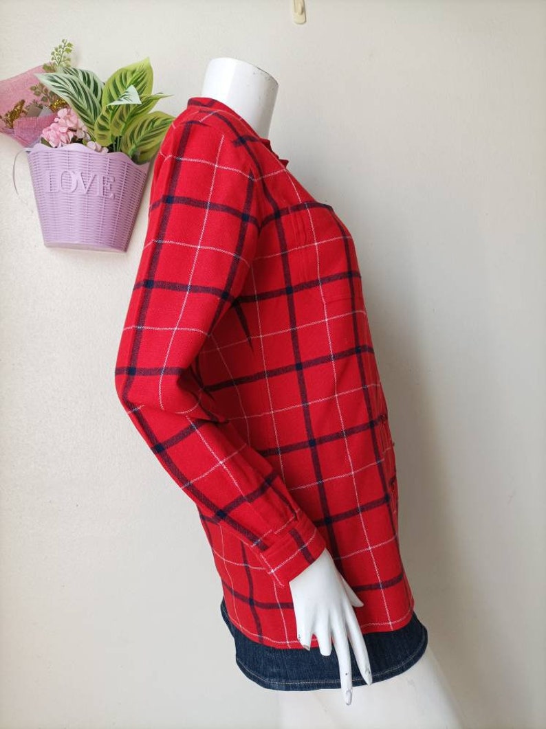 May include: Red and blue plaid long-sleeved shirt with a button-up front.