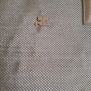 May include: A beige woven tote bag with a small, gold-coloured logo on the front.