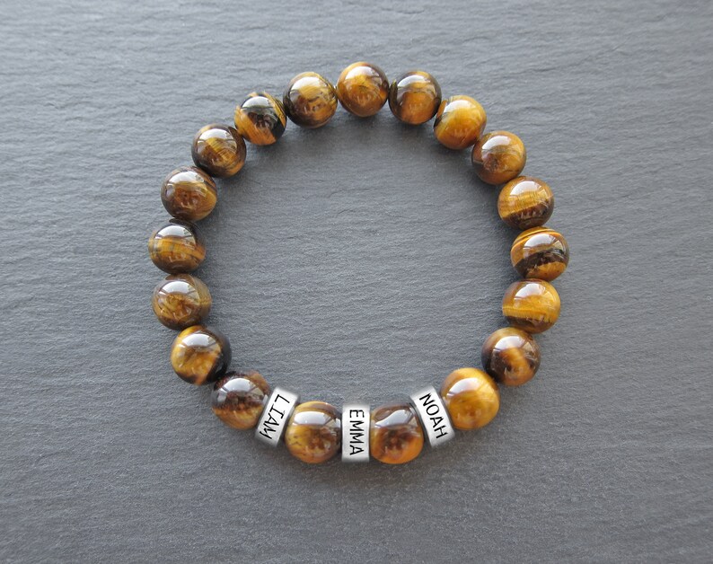 May include: Tiger's eye beaded bracelet with silver name beads that read "Liam", "Emma", and "Noah".