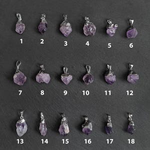 May include: Eighteen amethyst crystal pendants with silver settings. The pendants are arranged in three rows of six, numbered 1 through 18.