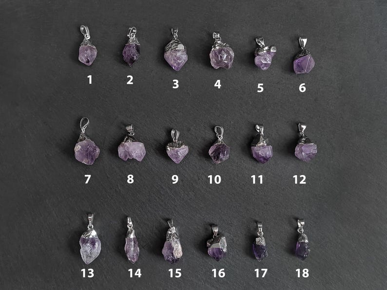 May include: Eighteen amethyst crystal pendants with silver settings. The pendants are arranged in three rows of six, numbered 1 through 18.