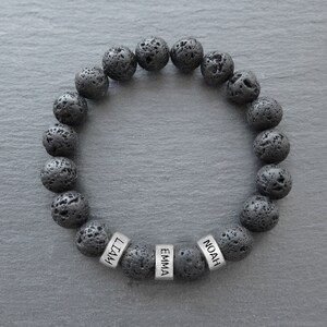 May include: Black lava rock beaded bracelet with silver name tags that read "Noah", "Emma", and "Liam".