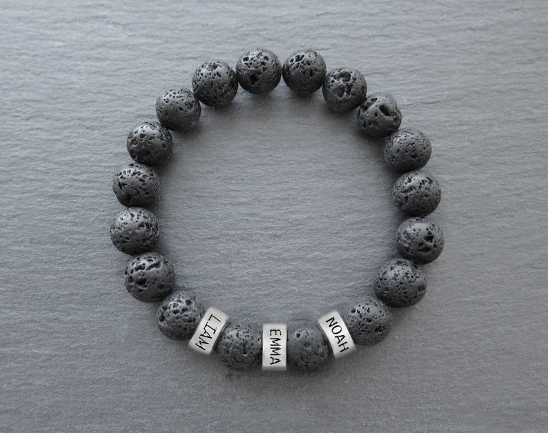 May include: Black lava rock beaded bracelet with silver name tags that read "Noah", "Emma", and "Liam".
