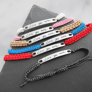 Può includere: Set di sette braccialetti dell'amicizia con chiusure regolabili in cordoncino nero. Ogni braccialetto presenta un'etichetta in metallo argentato con il messaggio scritto a mano "Love you more". I braccialetti sono di vari colori, tra cui bianco, rosa, oro, blu e rosso.