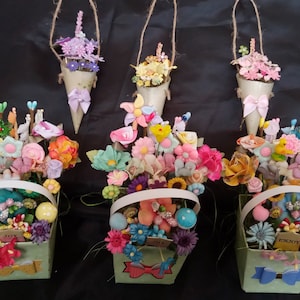 May include: Four green baskets filled with colorful artificial flowers and hanging from the ceiling. The baskets are decorated with ribbons and the words "Joy" and "Enjoy".