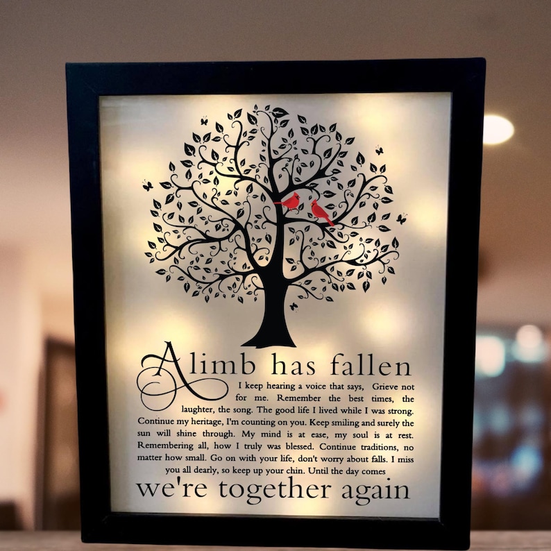 May include: A black framed illuminated sign with a black silhouette of a tree with red birds on the branches. The sign reads "A limb has fallen. I keep hearing a voice that says, Grieve not for me. Remember the best times, the laughter, the song. The good life I lived while I was strong. Continue my heritage, I'm counting on you. Keep smiling and surely the sun will shine through. My mind is at ease, my soul is at rest. Remembering all, how I truly was blessed. Continue traditions, no matter how small. Go on with your life, don't worry about falls. I miss you all dearly, so keep up your chin. Until the day comes we're together again."